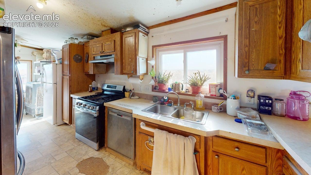 Kitchen featuring wood finish cabinetry, stainless steel appliances, and light countertops