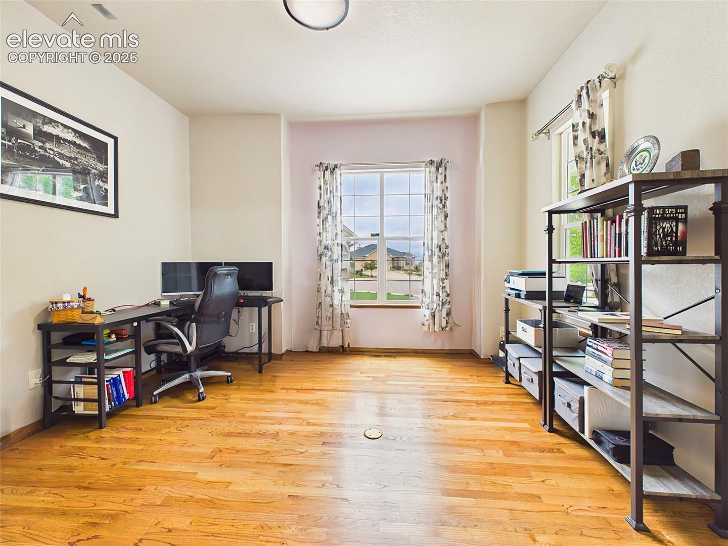Versatile office or flex space with hardwood flooring, abundant natural light, and room for work or study.