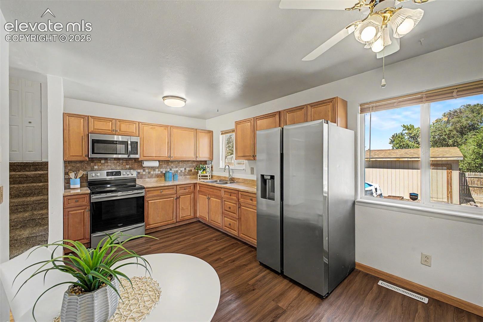 Kitchen with updated cabinets, newerr stainless steel appliances, and a mosaic tile backsplash