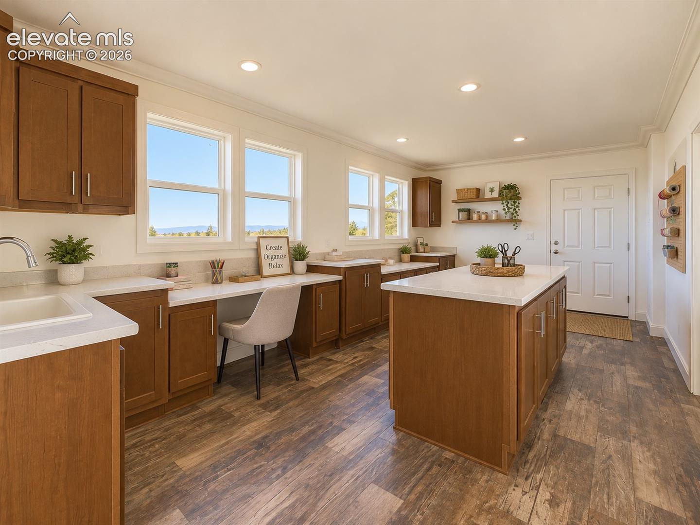 Oversized Laundry & Flex Room – Far more than a traditional laundry room, this spacious area features extensive cabinetry, countertops, a center work island, sink, and abundant natural light—ideal for laundry, crafts, projects, or a home office setup.