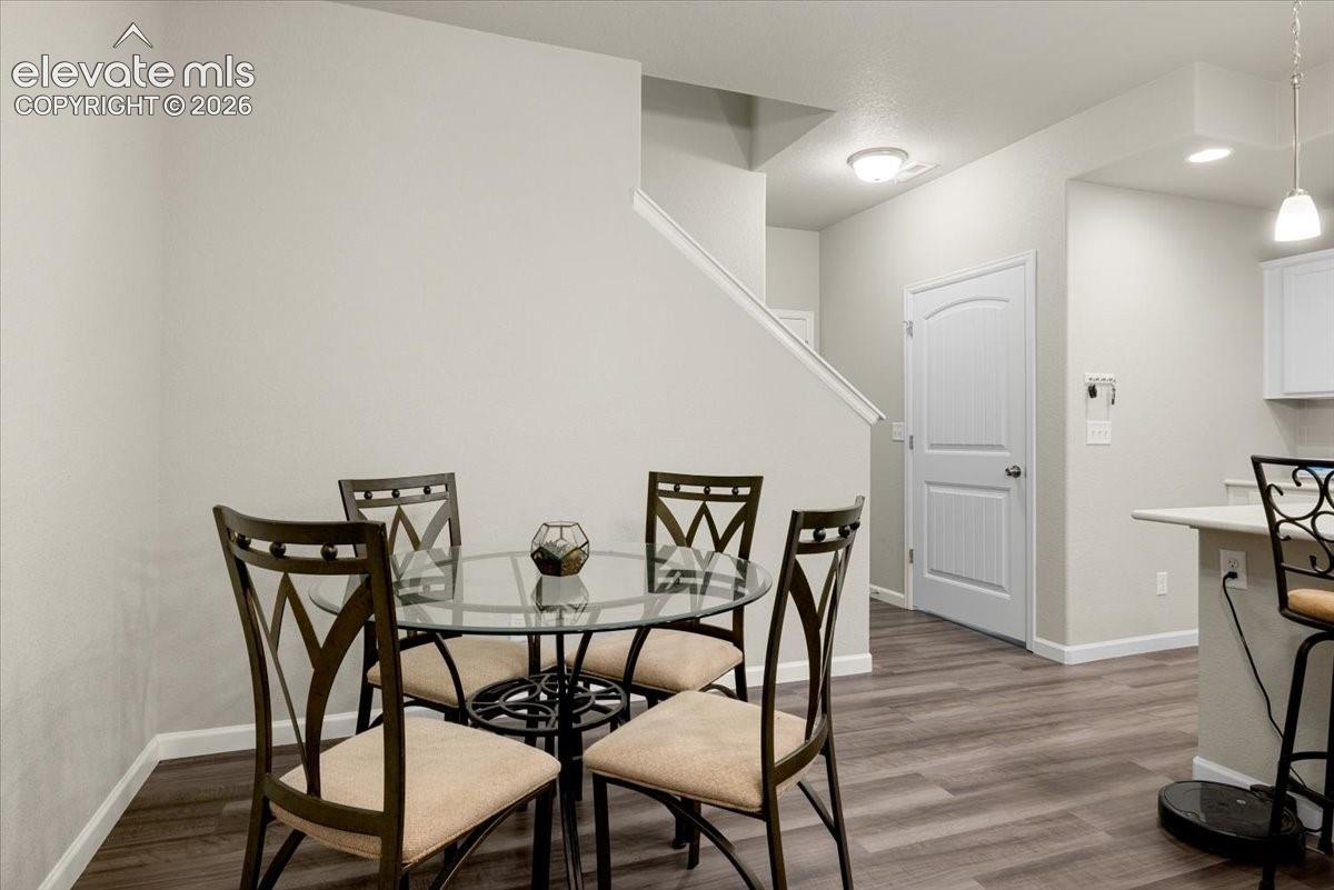 Wood-finish flooring throughout, light neutral wall paint, and a white interior door