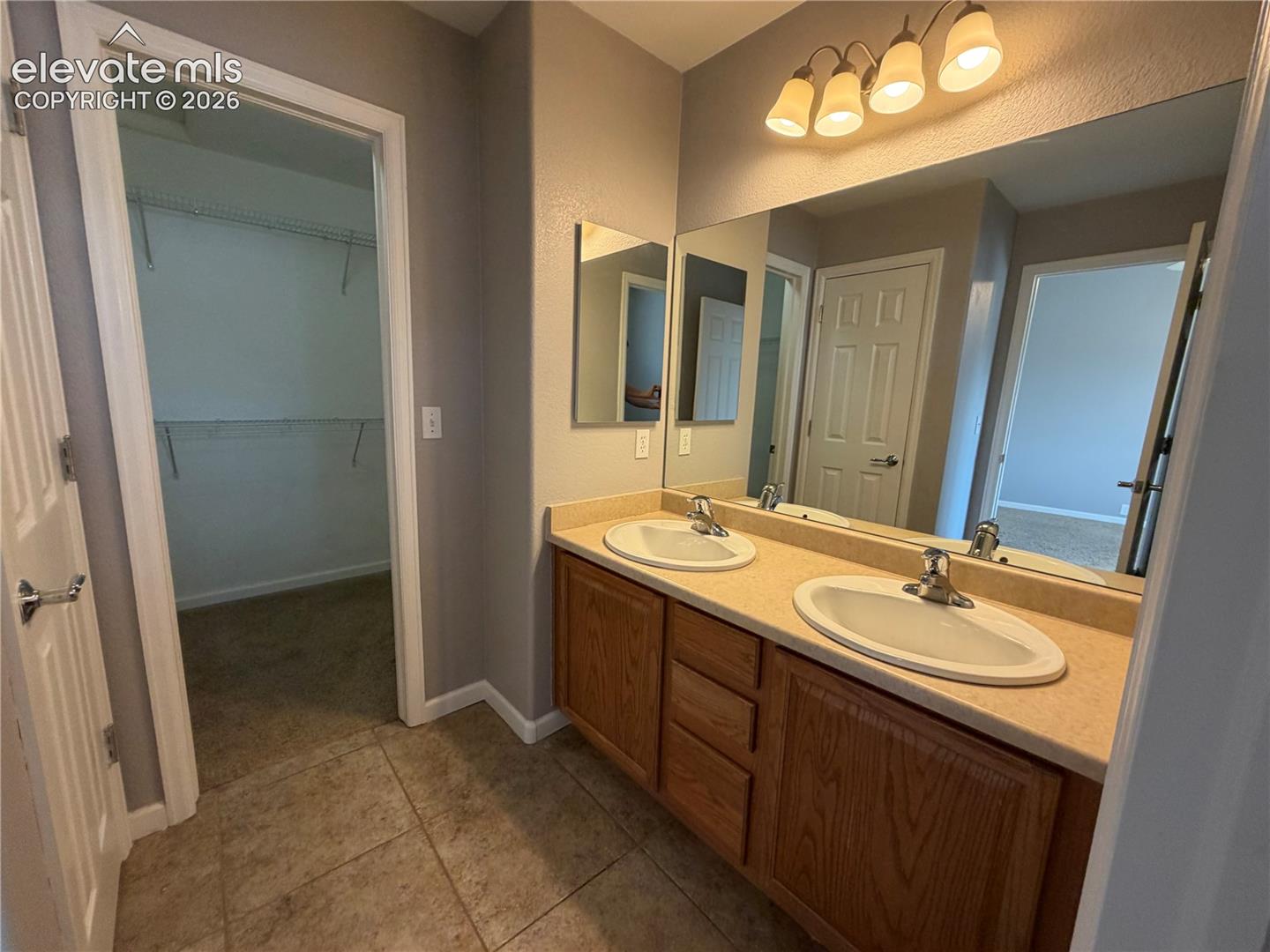Dual vanity with wood-finish cabinetry and integrated sinks