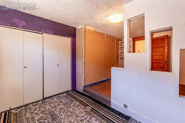 Unfurnished bedroom featuring a textured ceiling and a closet