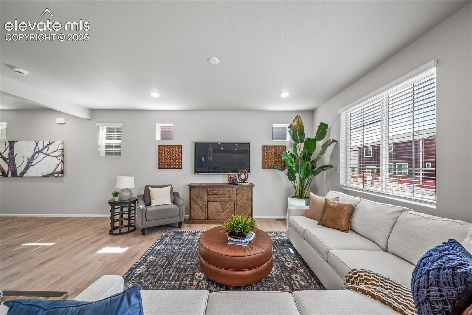 Recessed lighting throughout, wood-finish flooring, a large window with blinds, and built-in shelving
*photos of a model home*