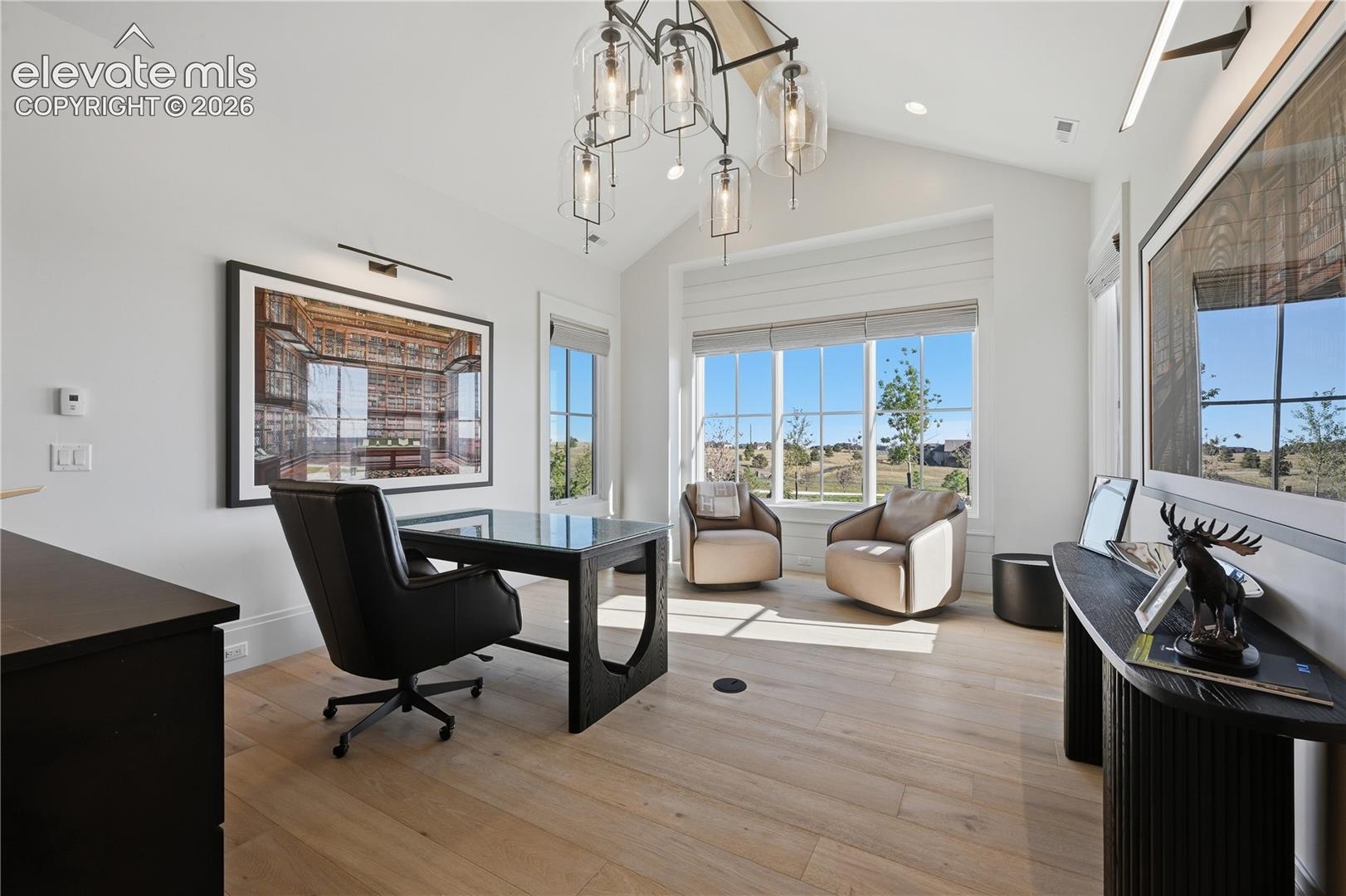 Vaulted ceiling with shiplap detailing, wood-finish flooring, multi-pane windows, and a multi-light chandelier