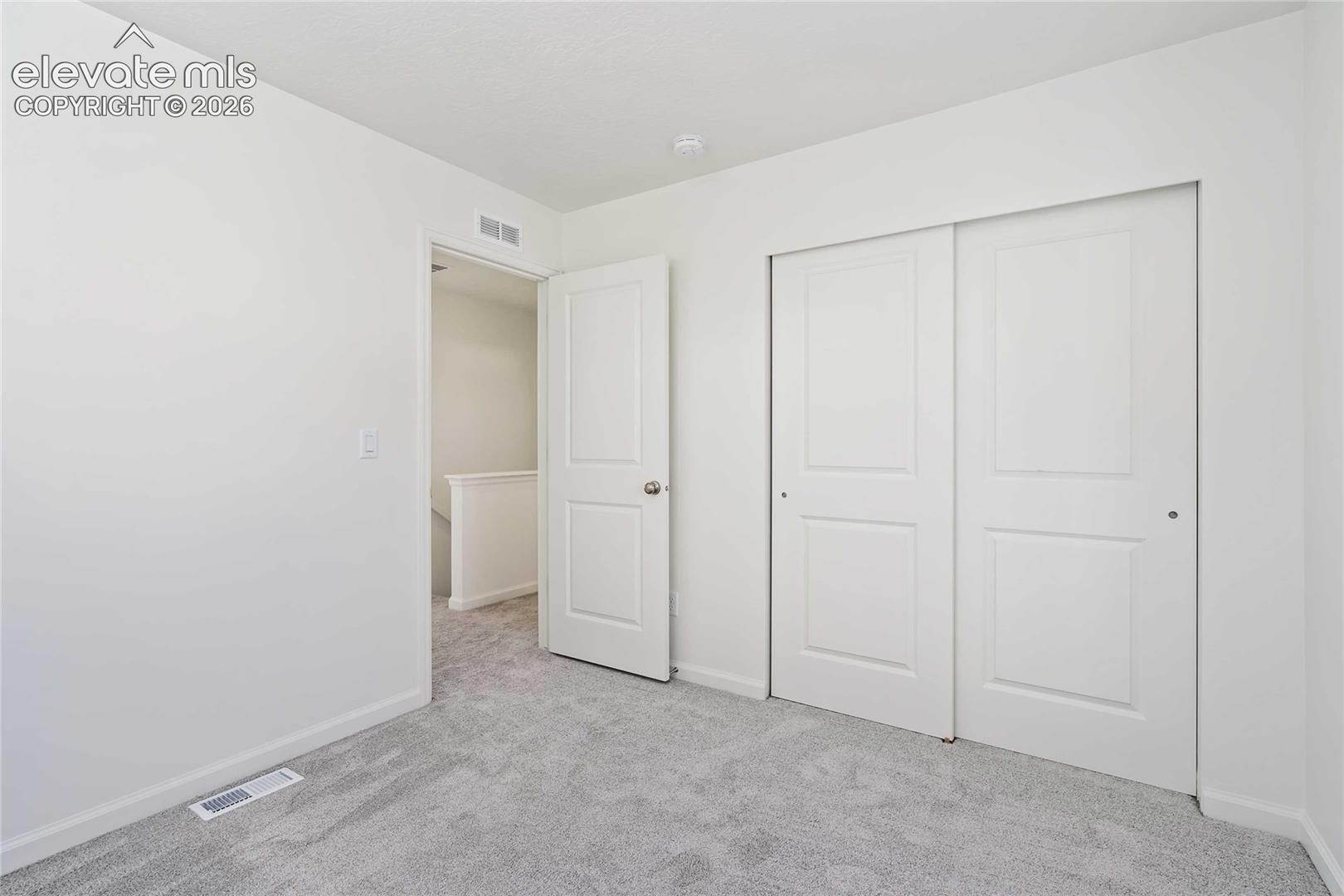 Plush grey carpeting, white interior walls, and contemporary sliding closet doors
*photos of a model home*