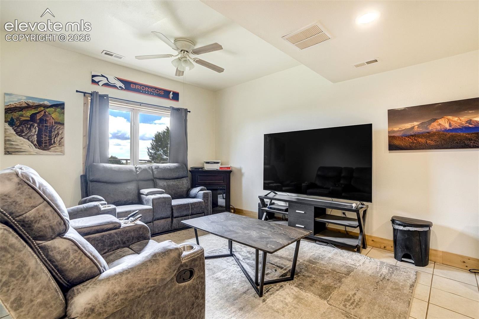 Interior room featuring a large window with white trim, a ceiling fan with integrated lighting, recessed lighting, and tiled flooring