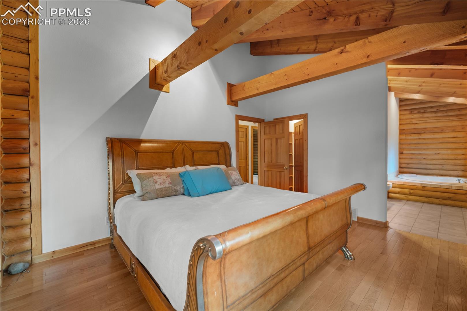 Bedroom with rustic walls and hardwood / wood-style flooring