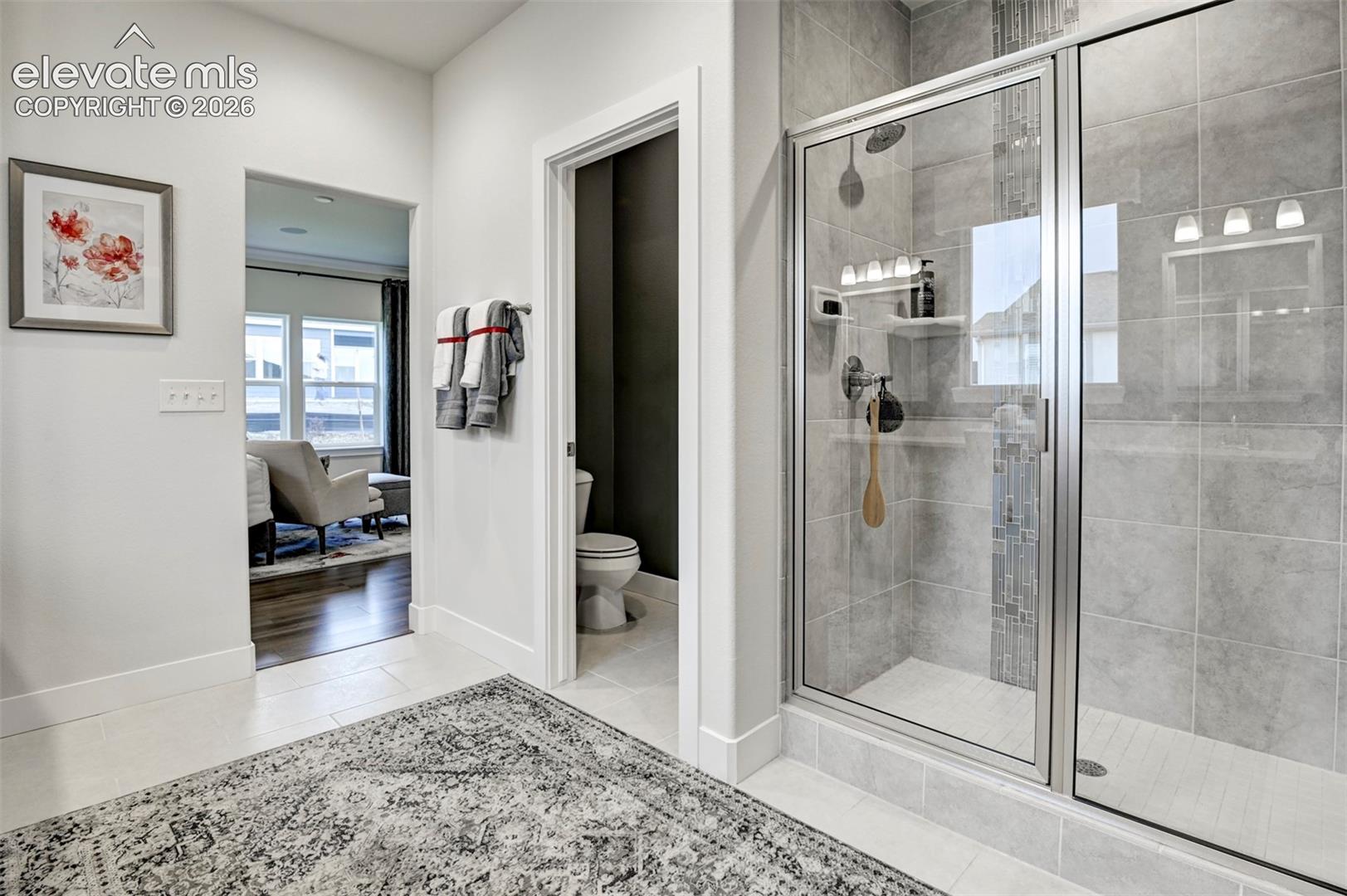 Glass-enclosed shower with gray tile surround and an integrated niche