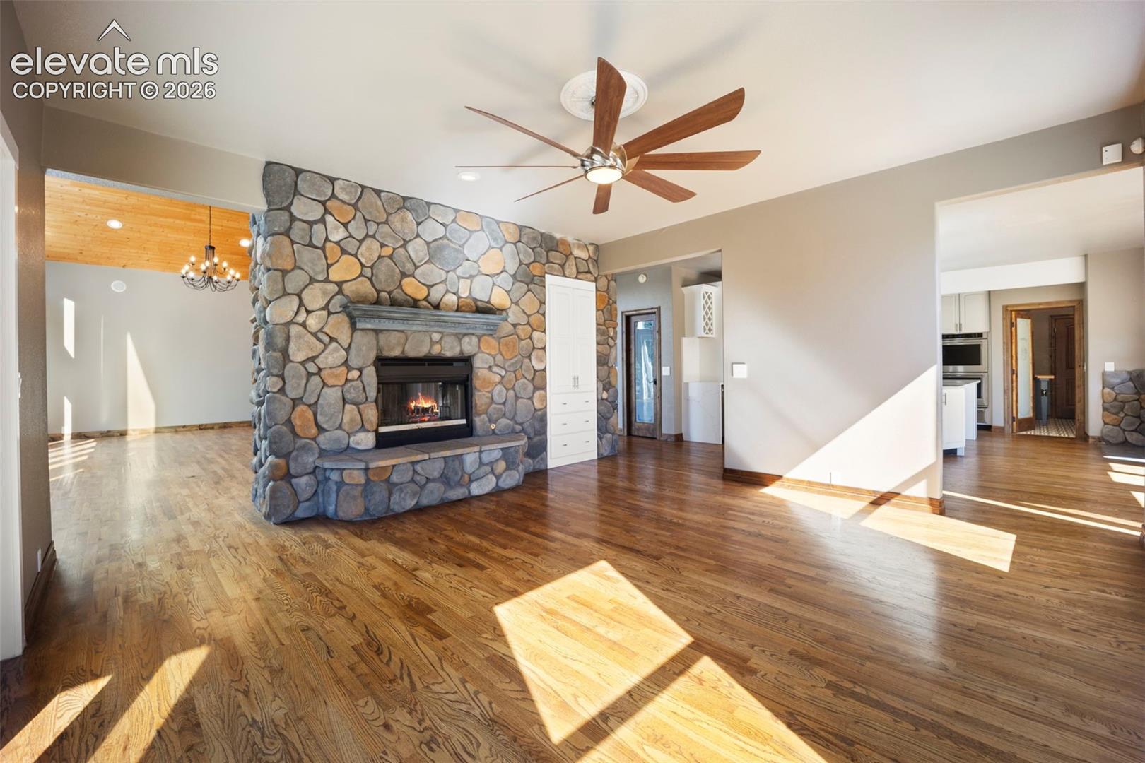 Stone-faced fireplace with hearth and wood mantel