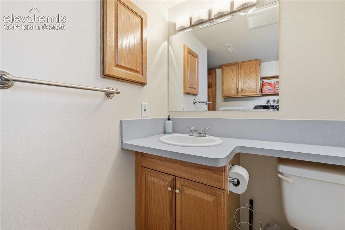 Vanity with an integrated sink, laminate countertop, and wood-finish cabinetry