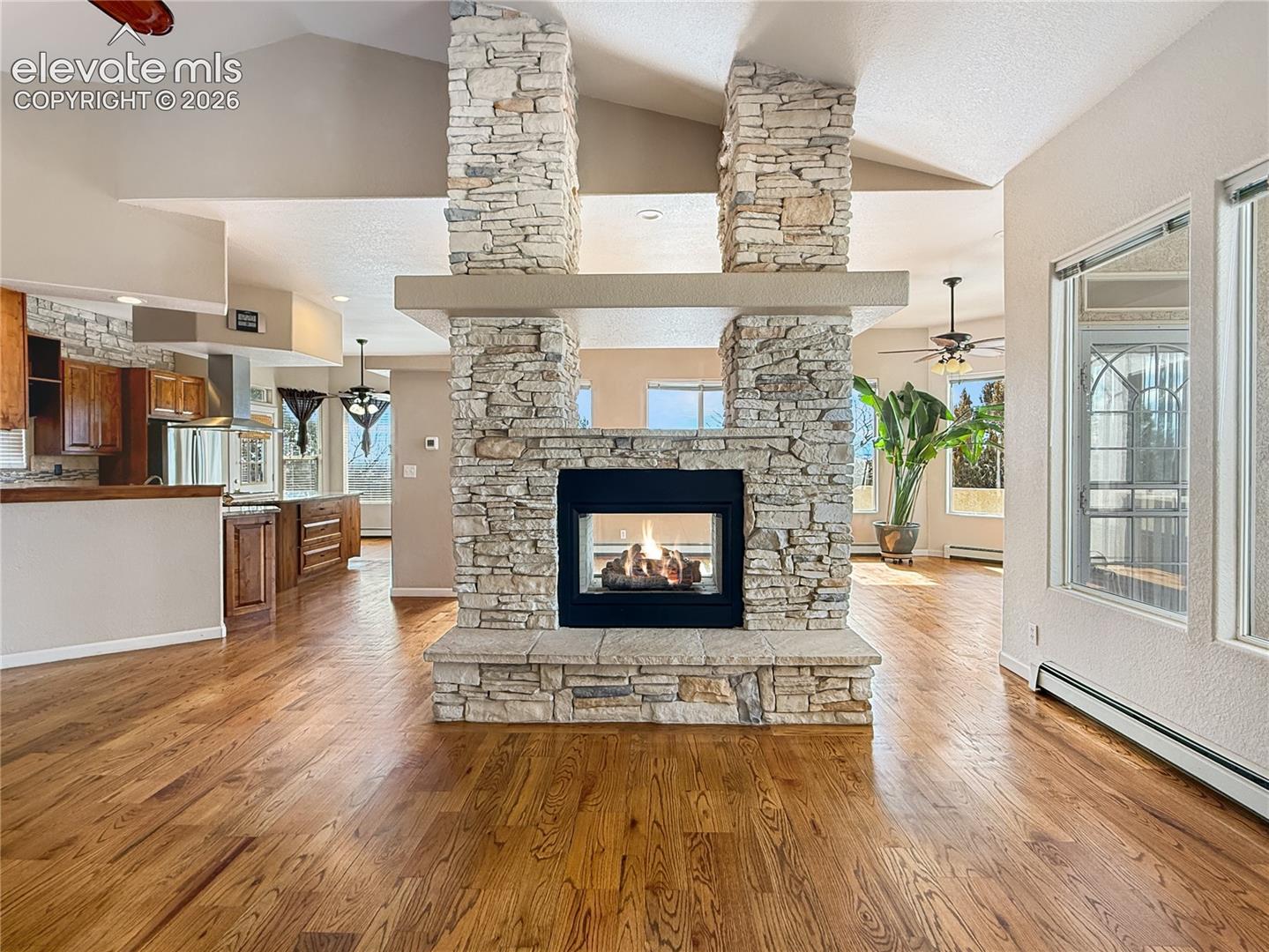 Two way gas fireplace viewed from living room, dining area on the other side