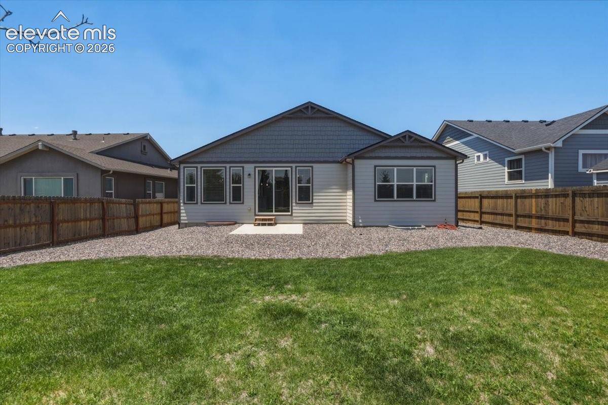 Rear exterior featuring a concrete patio, sliding glass door, and multiple windows