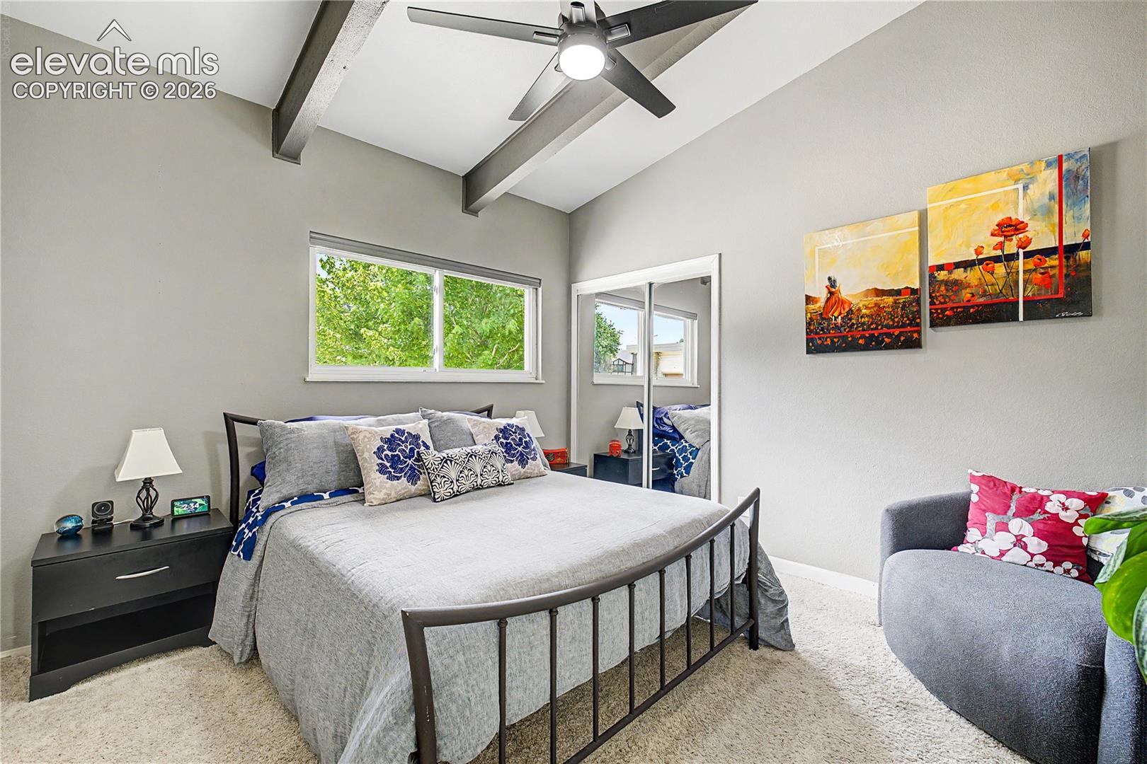 A secondary bedroom carries forward the home's signature vaulted, beamed ceilings, proof that this architectural style runs throughout the house.