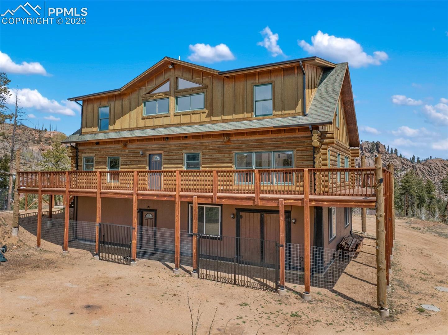 Log cabin style home with a full-width deck featuring wooden railings