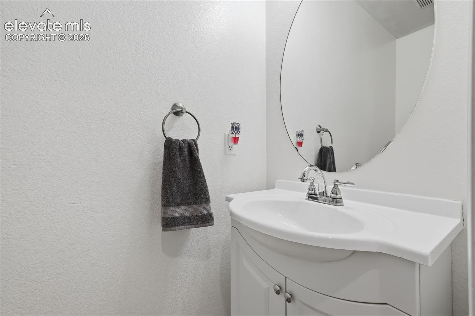 White vanity with an integrated sink and chrome faucet