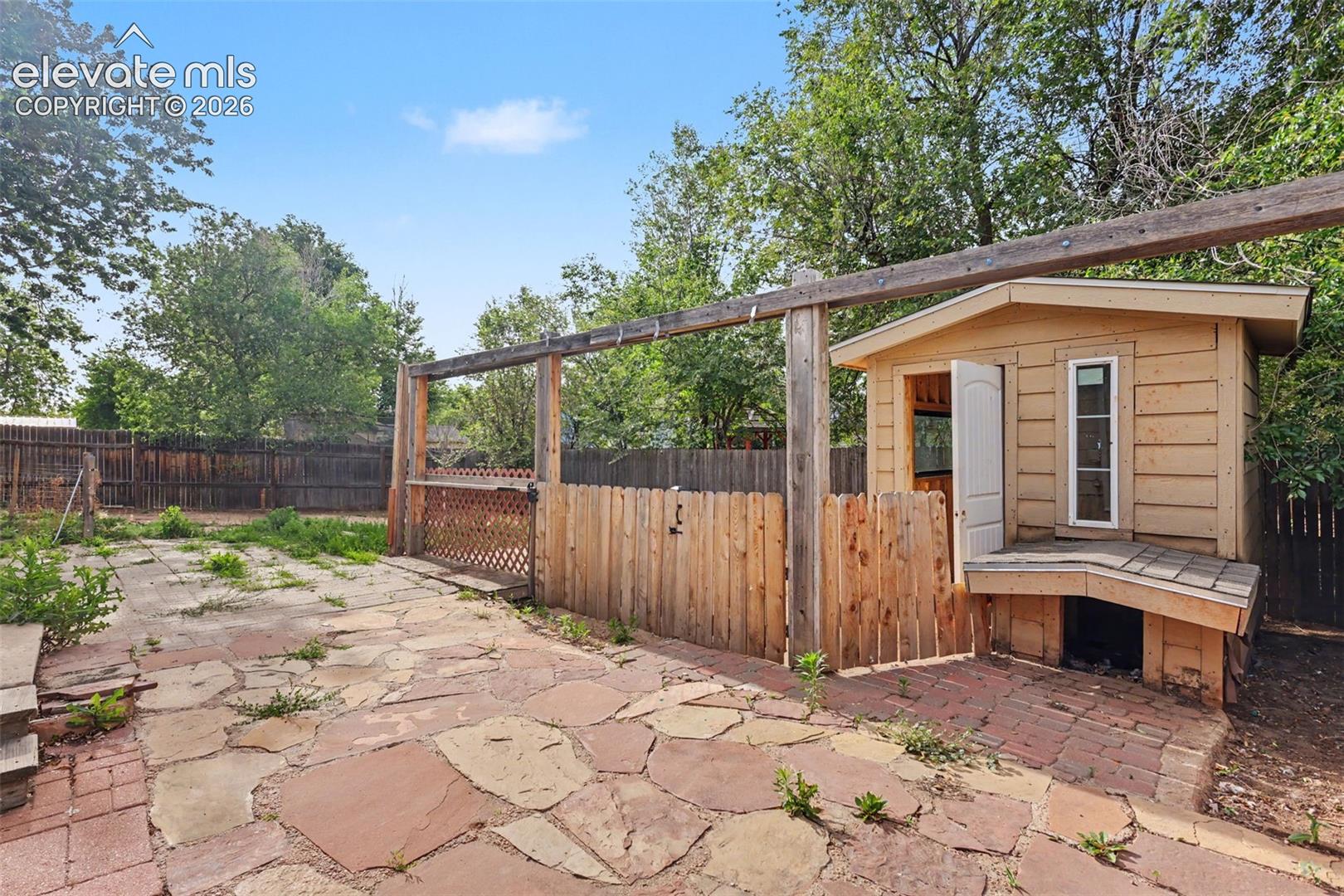 Backyard includes a shed/playhouse and flexible outdoor space.