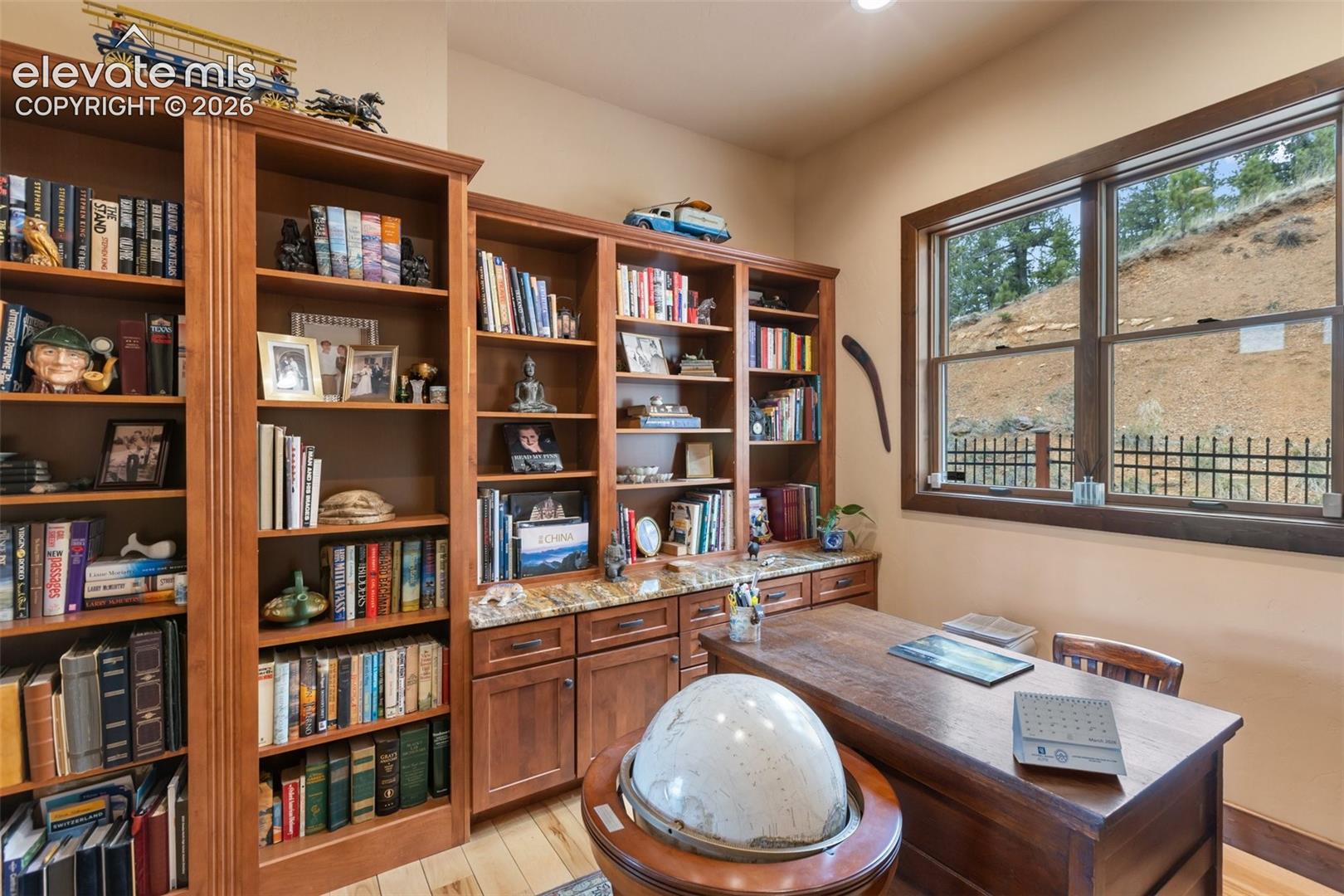 Office with built ins and book shelves, french doors.