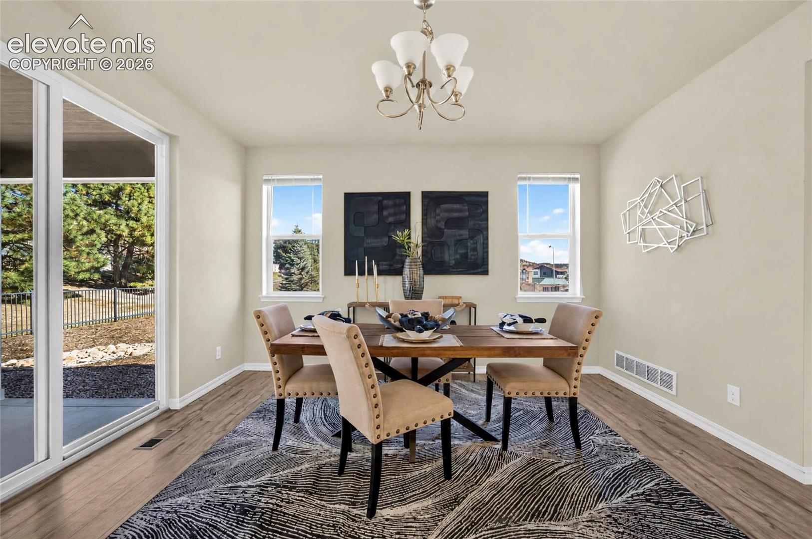 Dining space with wood-laminate finish flooring, and multiple windows providing natural light