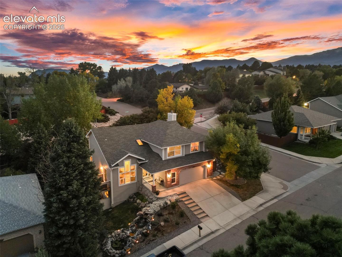 Two-story residence featuring a gray exterior, attached two-car garage, and a concrete driveway