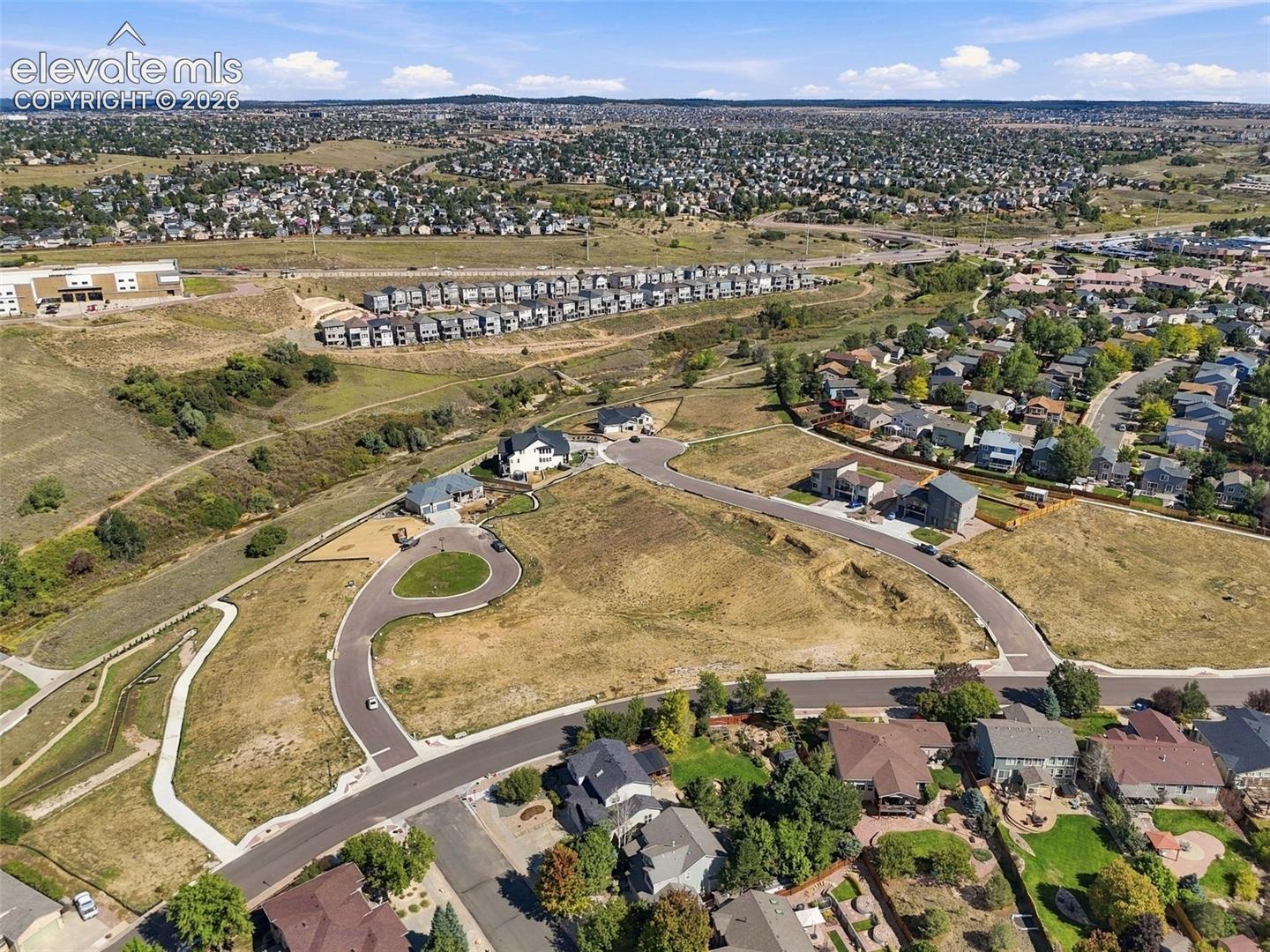 Expansive undeveloped land parcels with paved access roads and surrounding residential areas
