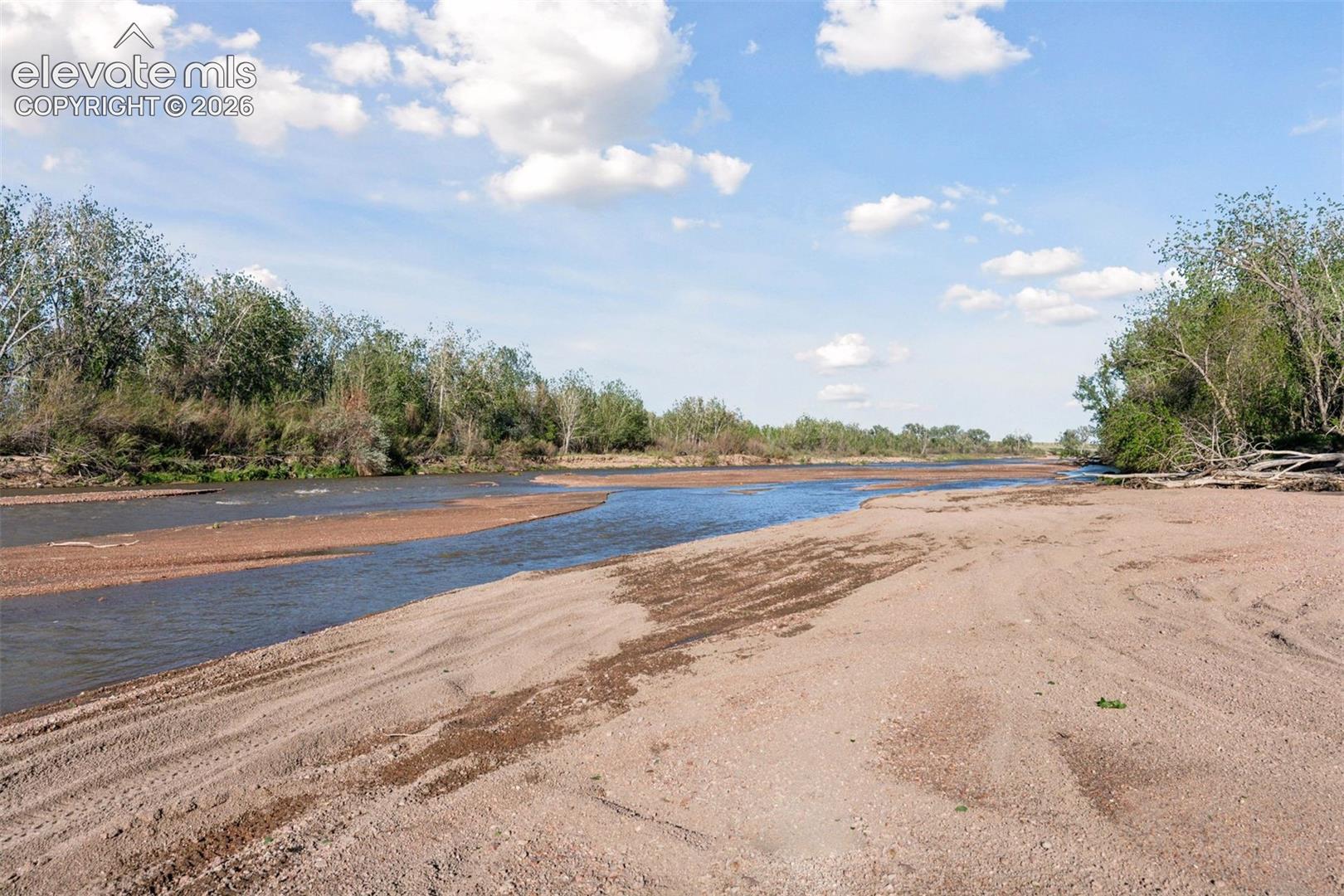 Downstream view of Fountain Creek with seasonal sandbars and riparian greenery