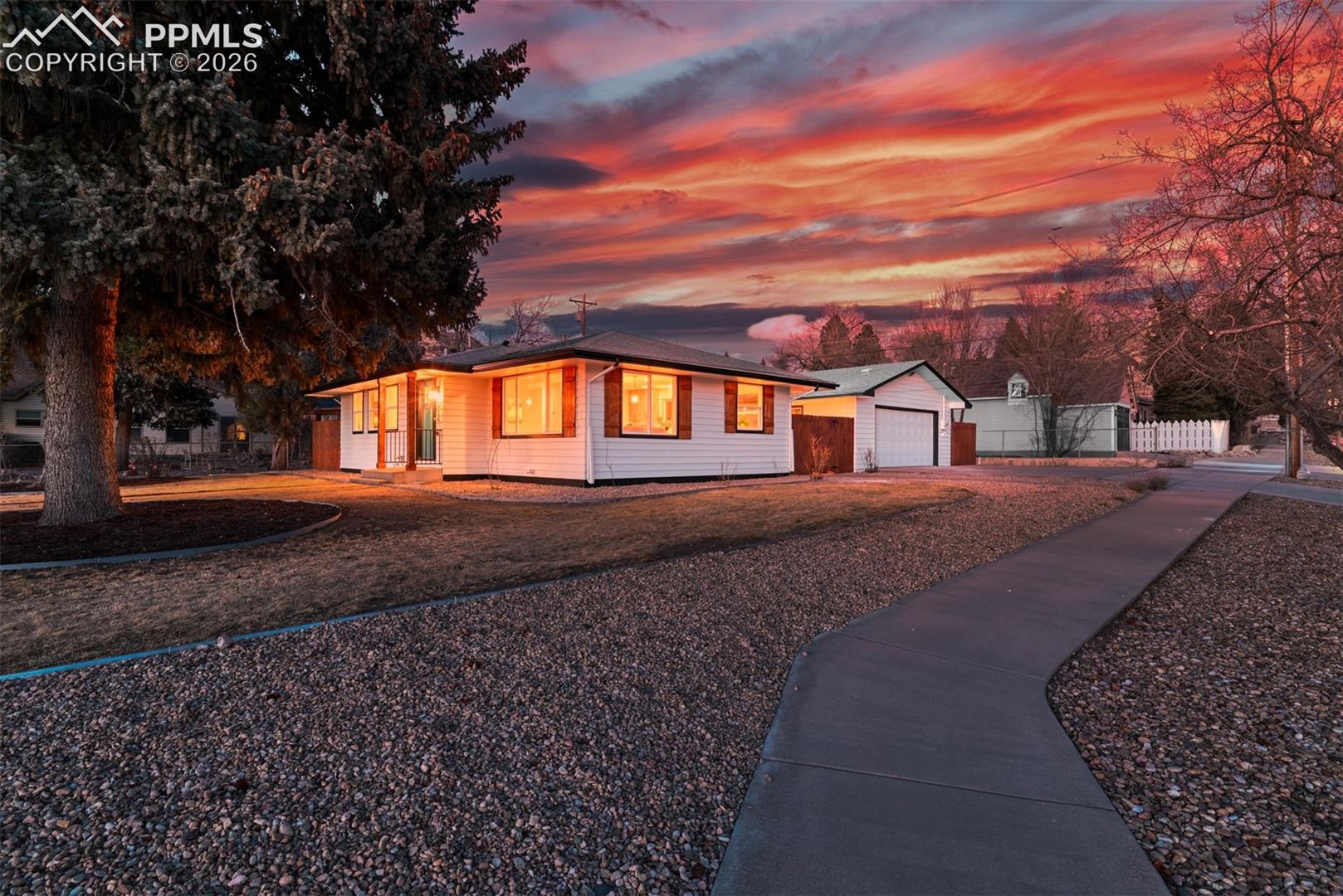 View of front of home with driveway, an outdoor structure, and a garage
