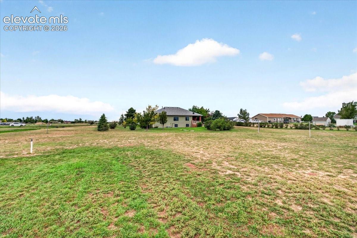 Expansive lot featuring open grounds, mature trees, and a detached residence