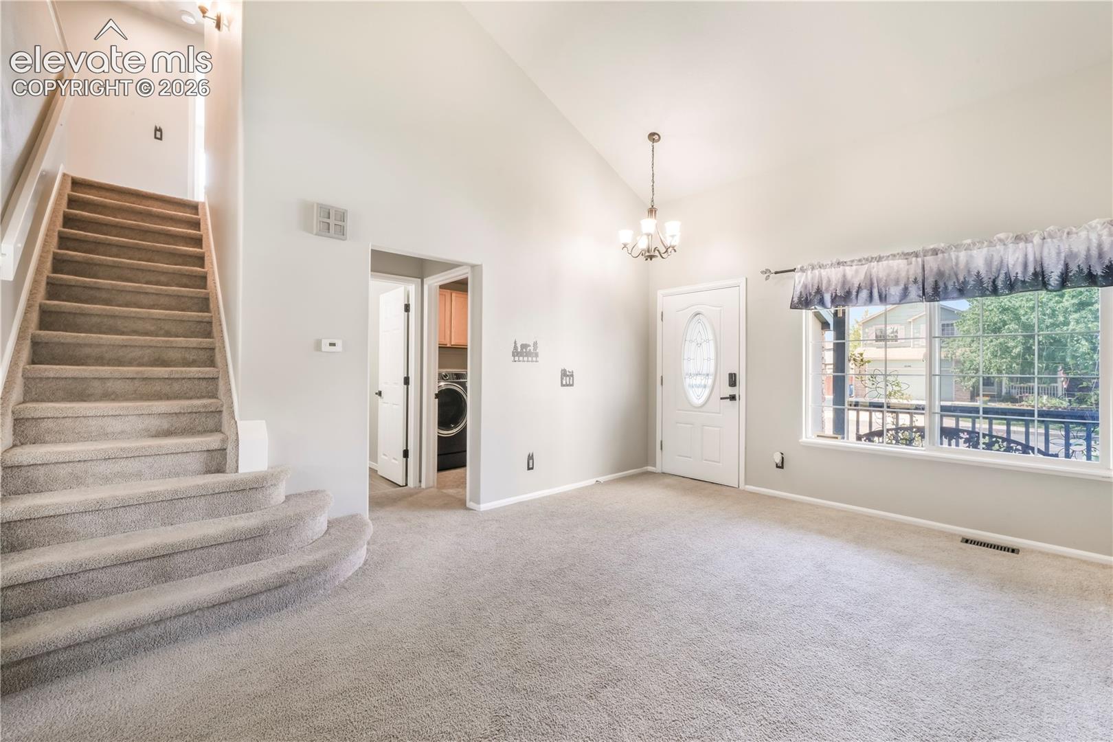 Entry, front formal living room and views of laundry room with access to garage door