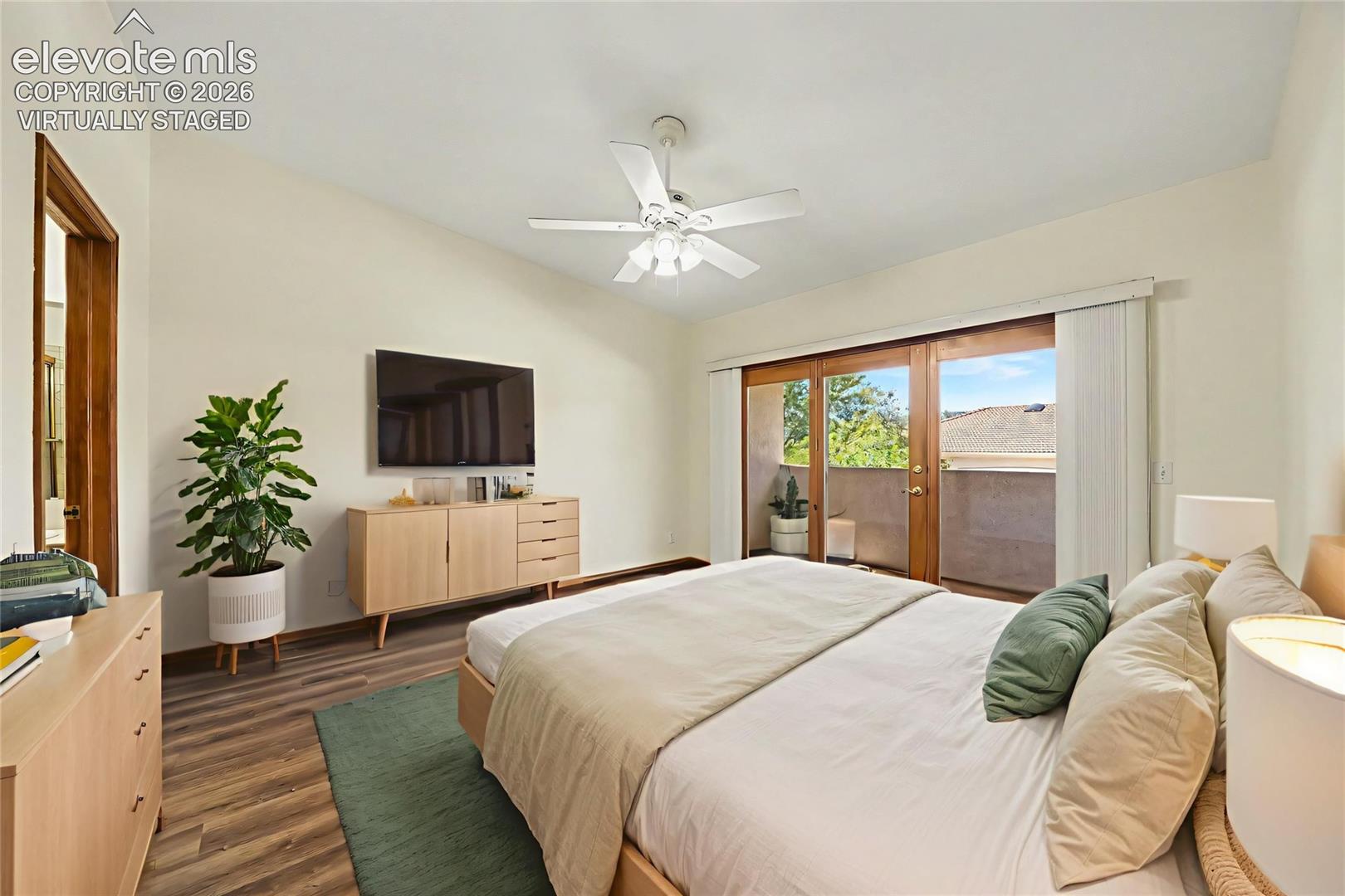 Virtually staged. Vaulted ceiling with a ceiling fan, LVP flooring, and sliding glass doors opening to an outdoor deck area