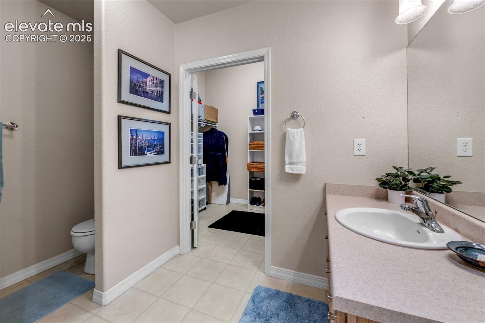 Built-in vanity with integrated sink, chrome faucet, and expansive wall-mounted mirror