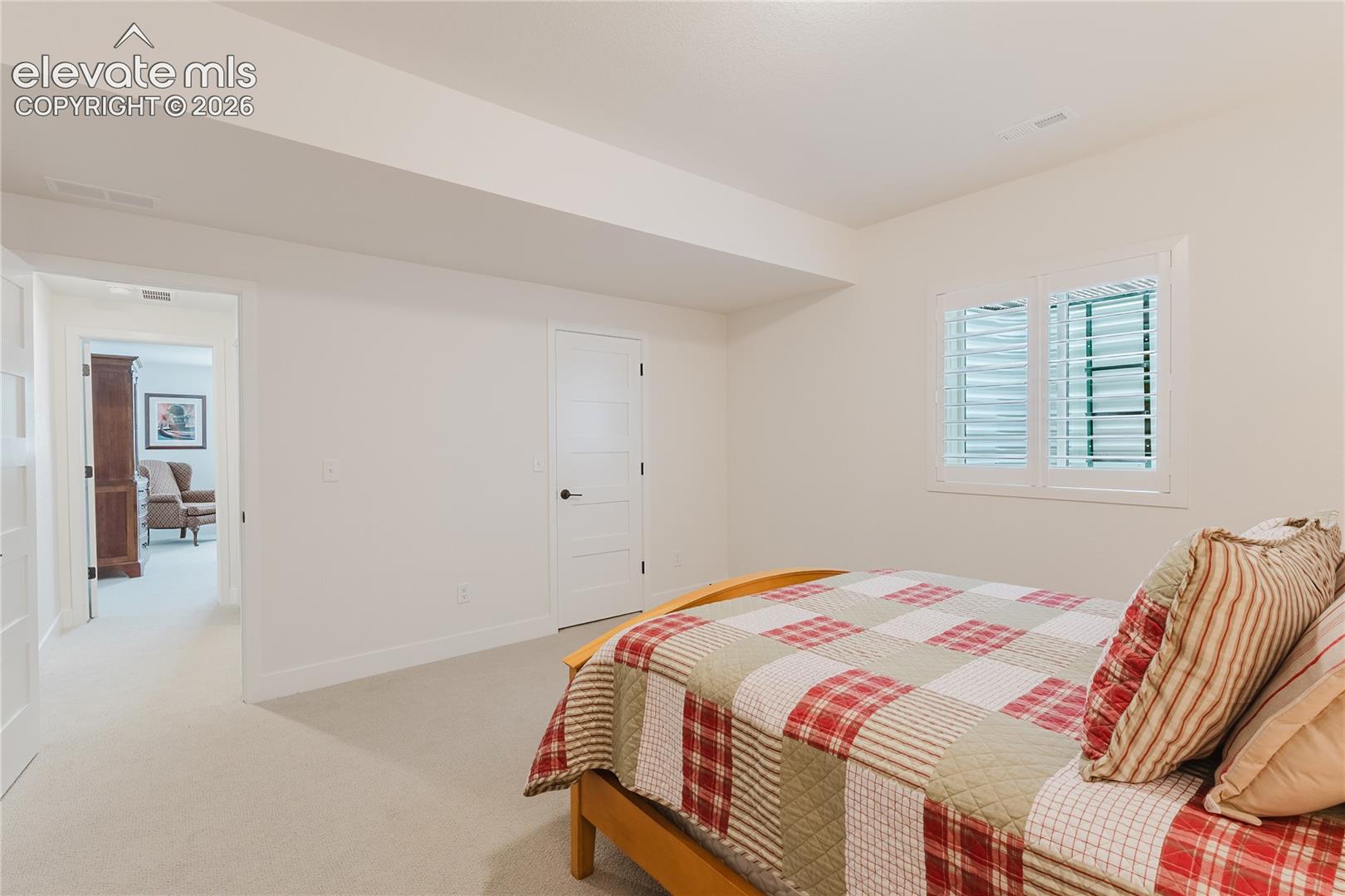 Bedroom in the lower level with plantation shutters and a walk in closet