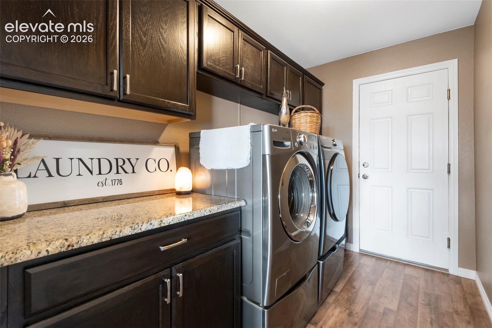 Main Level Laundry Room with Cabinets Galore, Granite Counters, and Deep Laundry Room Utility Sink, and Garage Access 