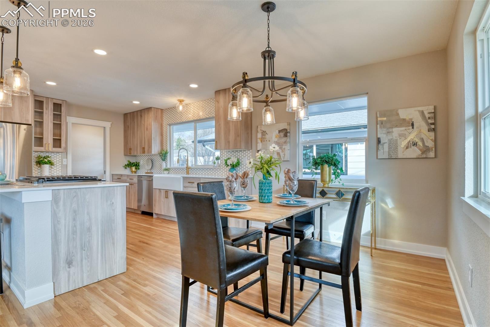 Dining room with light wood-style flooring and hanging lights