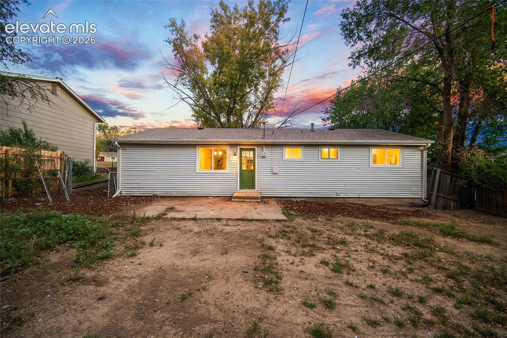 Rear exterior with horizontal siding and a green entry door