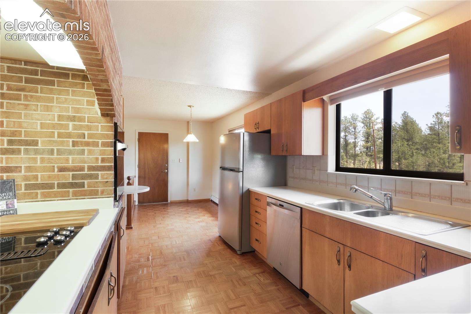 Kitchen off the entry with brick around cooktop