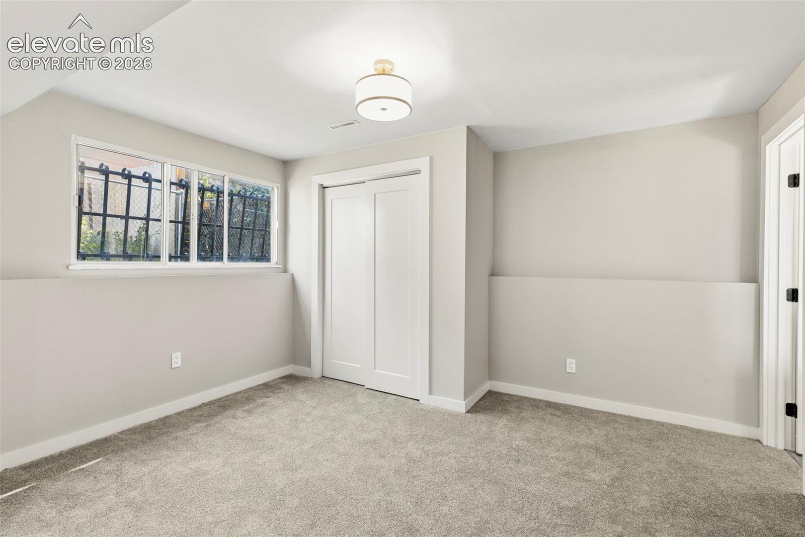 Wall-to-wall taupe carpet flooring with a white trim baseboard
