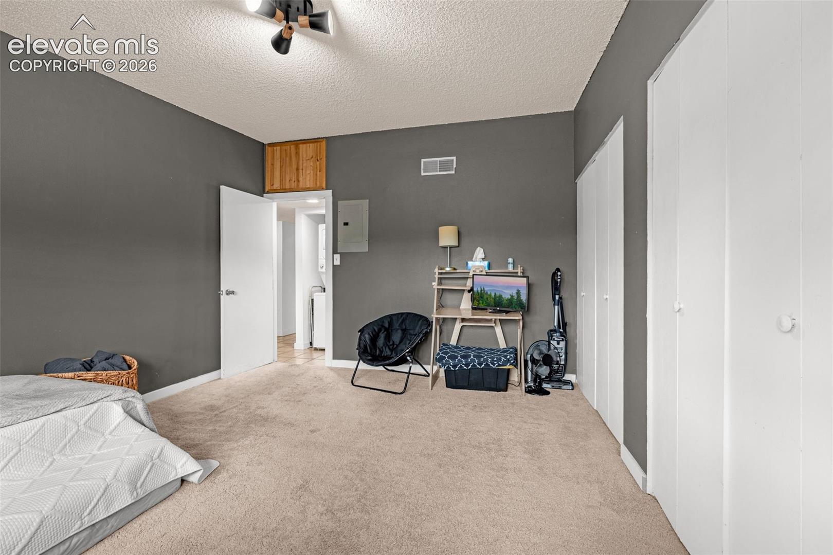 Carpeted flooring, white interior doors, and a ceiling-mounted light fixture