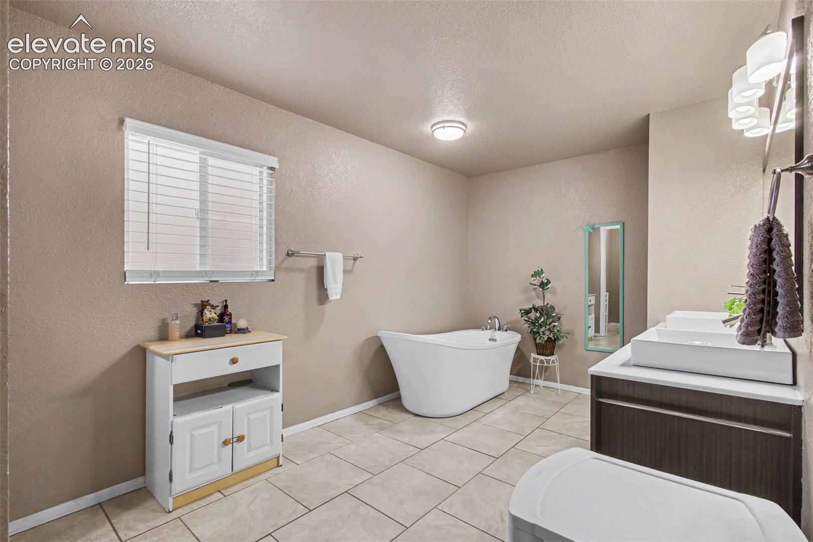 Elegant freestanding soaking tub offers the perfect spot to relax, unwind, and enjoy a spa-like experience at home.