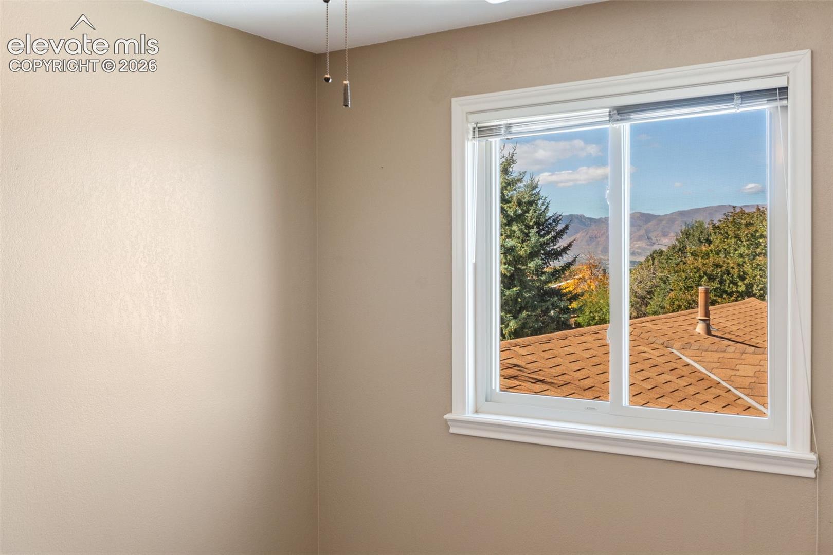 Window featuring white trim and mountain and tree scenery, complemented by neutral-toned walls