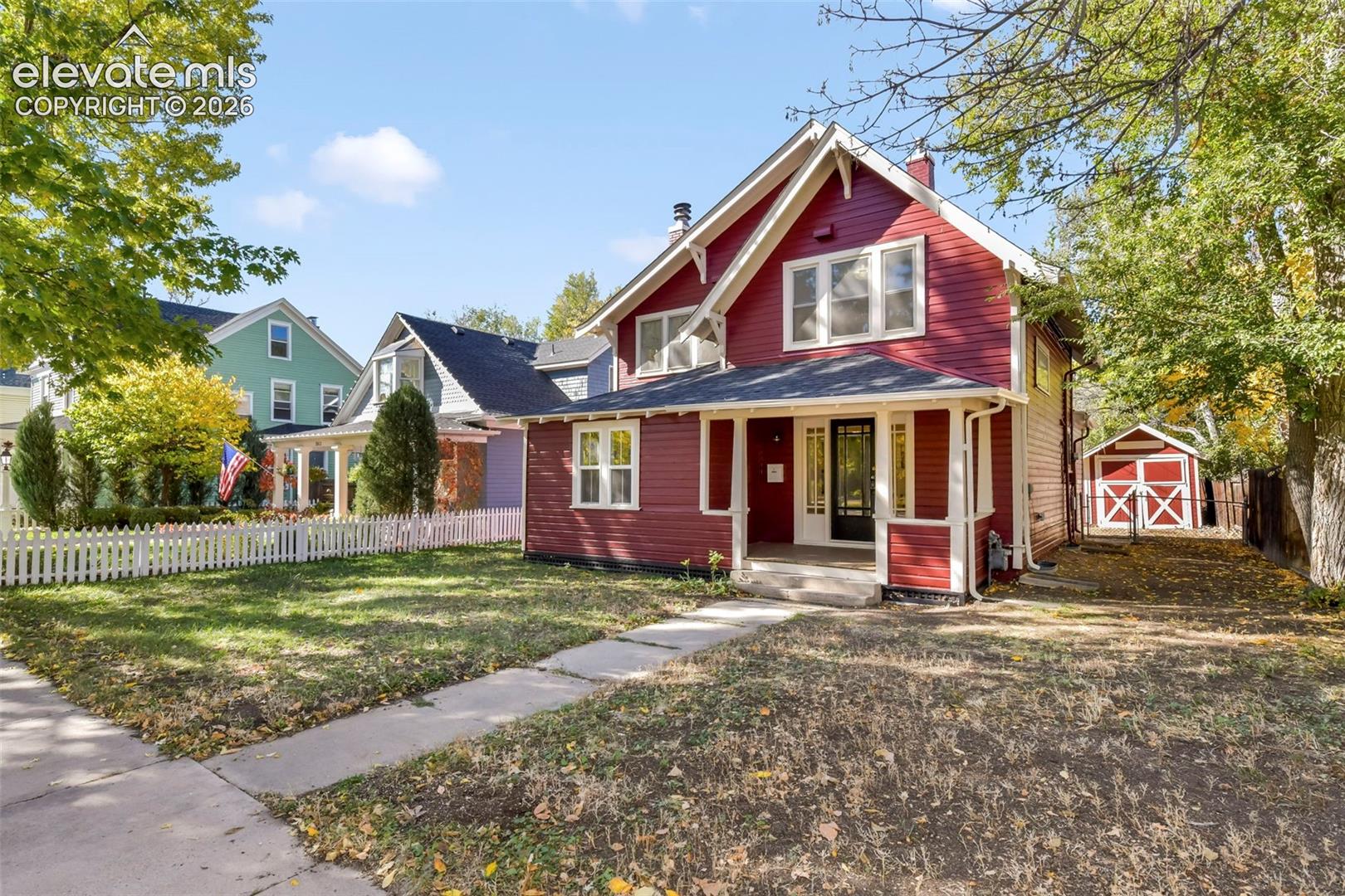 Two-story residence featuring horizontal lap siding, a covered front porch, gable roofline, and a detached structure