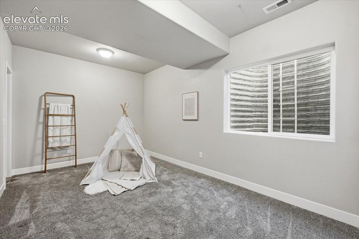 Light gray wall color, neutral carpeting, white trim, recessed lighting, and a white-framed window