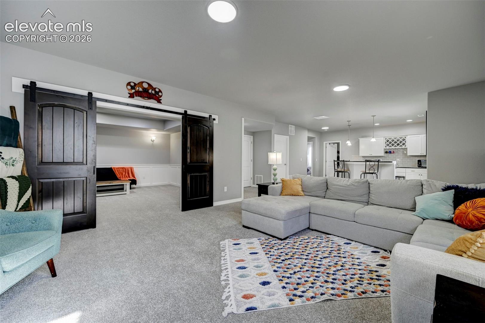 Spacious living area featuring light gray walls, recessed lighting, and a neutral carpet