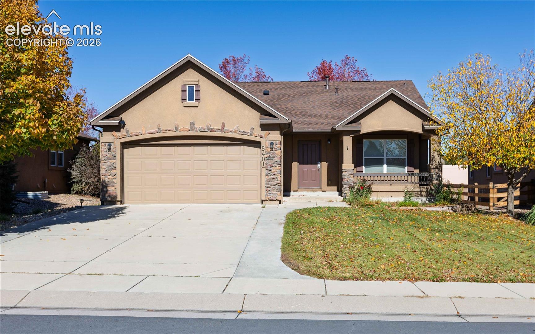 Single-story exterior featuring a stucco facade, stone veneer accents, an attached two-car garage, and a covered front porch
