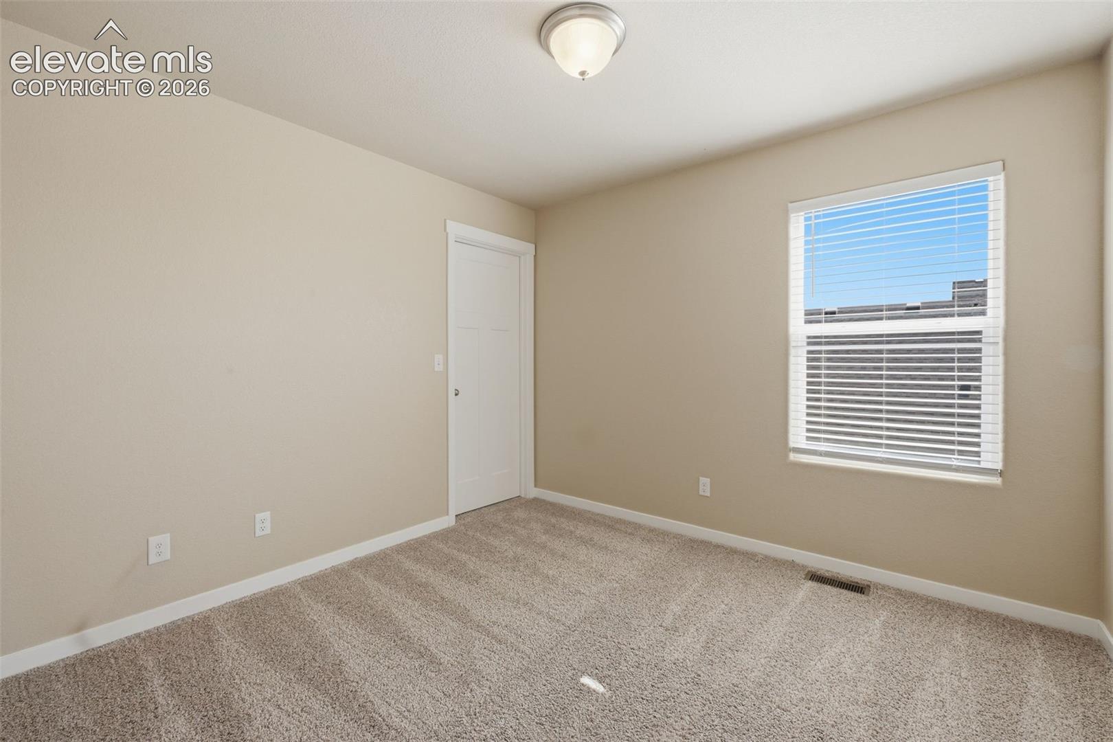 One of three secondary bedrooms upstairs, offering comfortable space and abundant natural light.