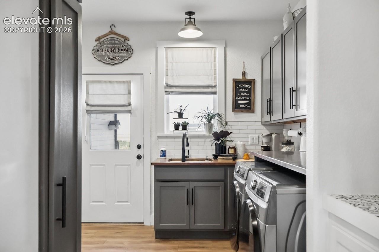 Large mudroom with full-sized washer and dryer, plus access to garage and outside