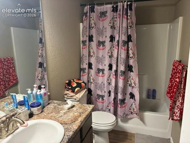 Bathroom featuring a stone-patterned laminate countertop, integrated oval sink basin, chrome-finish dual-handle faucet, full-width wall mirror, and a combined tub and shower unit with a molded surround