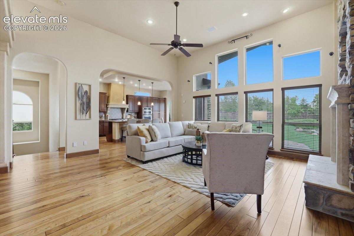 Spacious Great Room with vaulted ceiling, custom built-ins, Gas fireplace with Stone Surround, Speakers, and Wood Flooring!