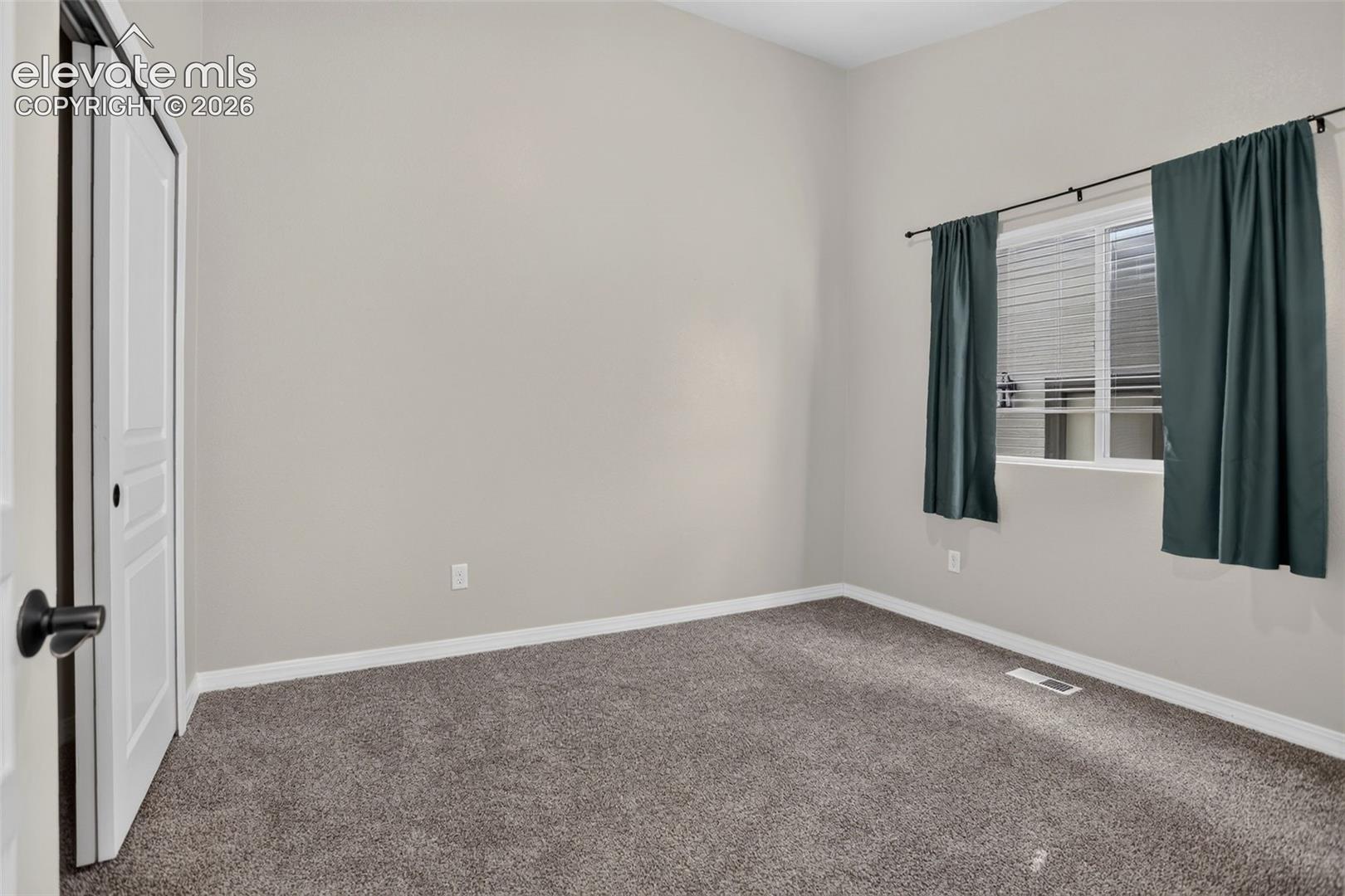 Carpeted flooring, neutral wall paint, and a window with blinds