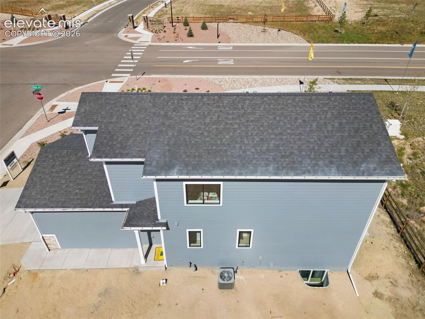 Two-story property with gray shingle roofing, blue horizontal siding, and white trim accents